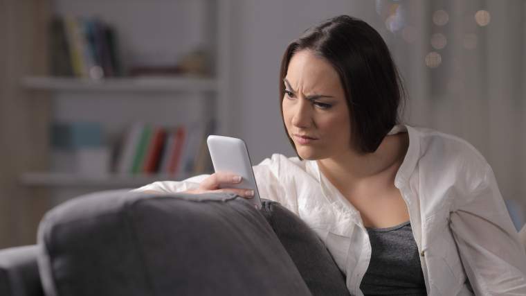 unimpressed woman reading info on her phone