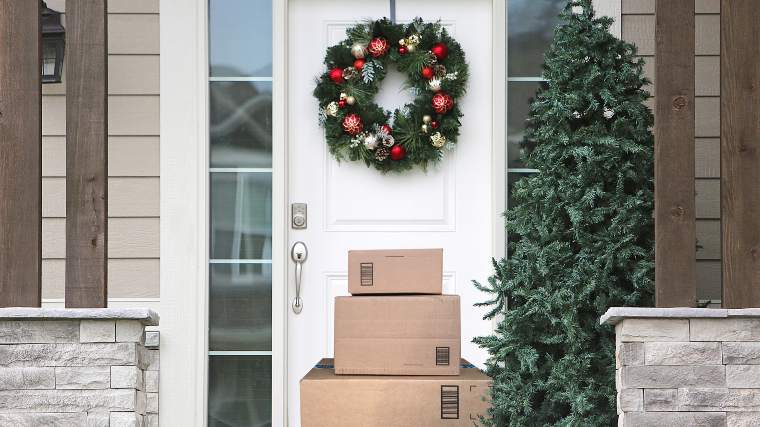 stack of delivery boxes under a Christmas wreath on a doorstep