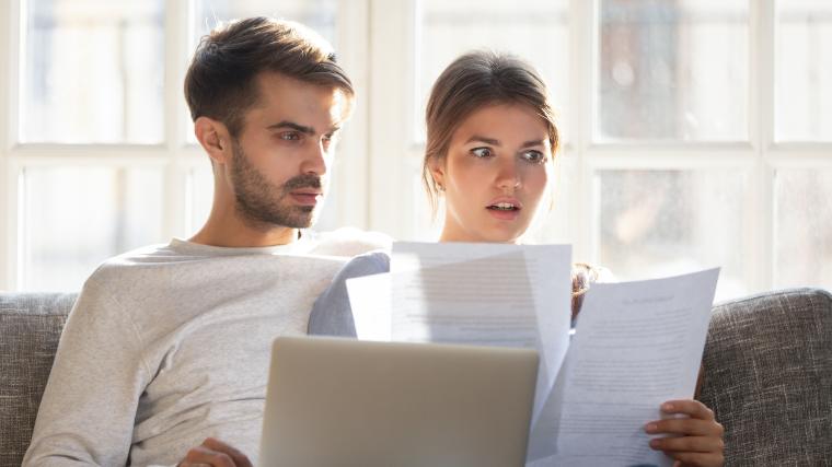 Young couple on the couch and shocked by credit score