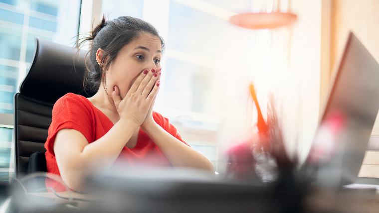 Excited woman looking at laptop.