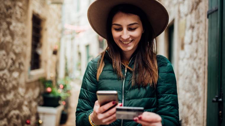 woman making a purchase on her phone with a credit card