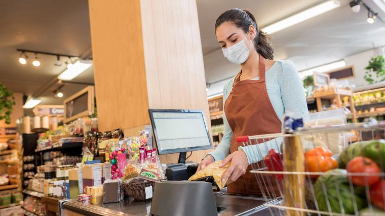 cashier in grocery wearing face covering