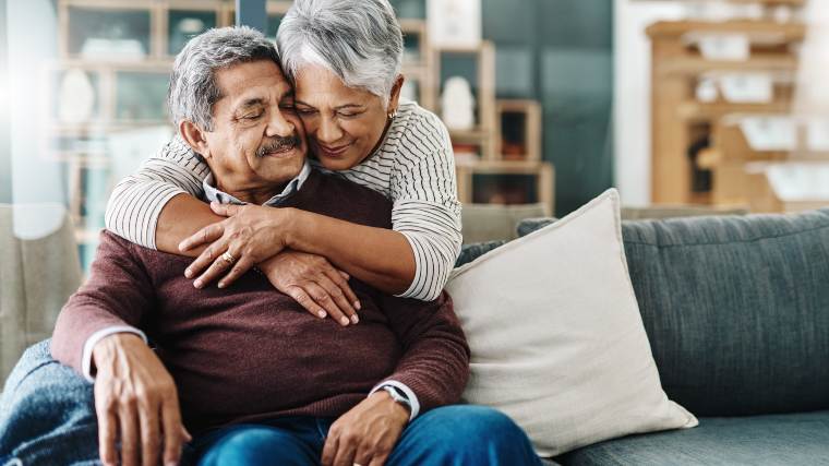 Senior couple hugging on the couch