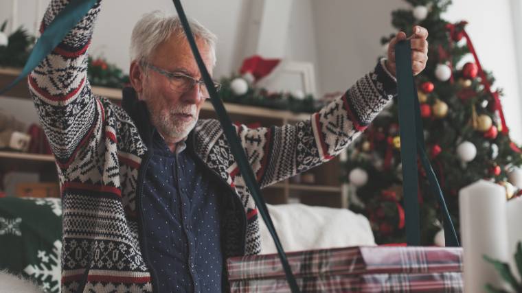 older gentleman wrapping a Christmas present