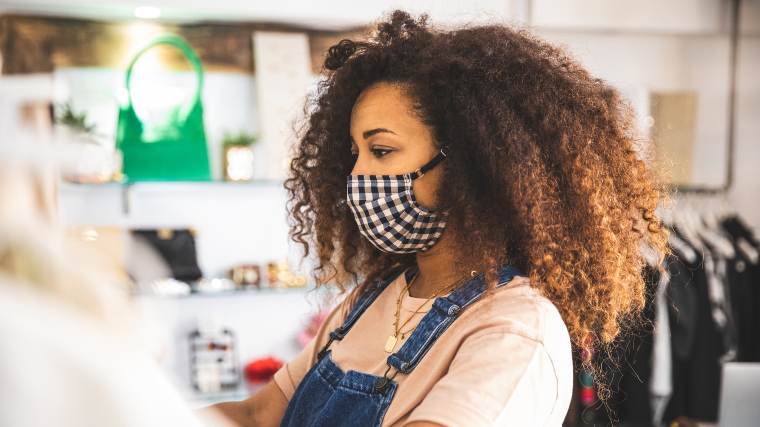 woman out shopping in a clothing store while wearing a facial covering