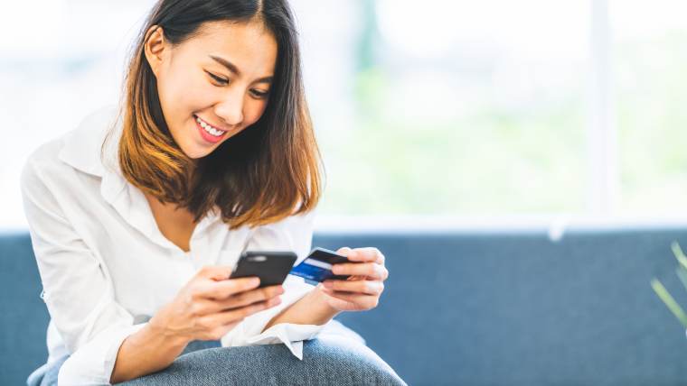 woman holding a credit card and a cellphone