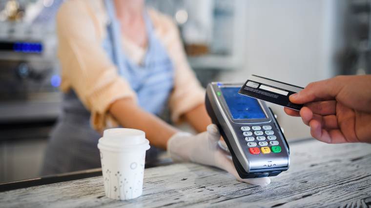 using a credit card at a coffee shop
