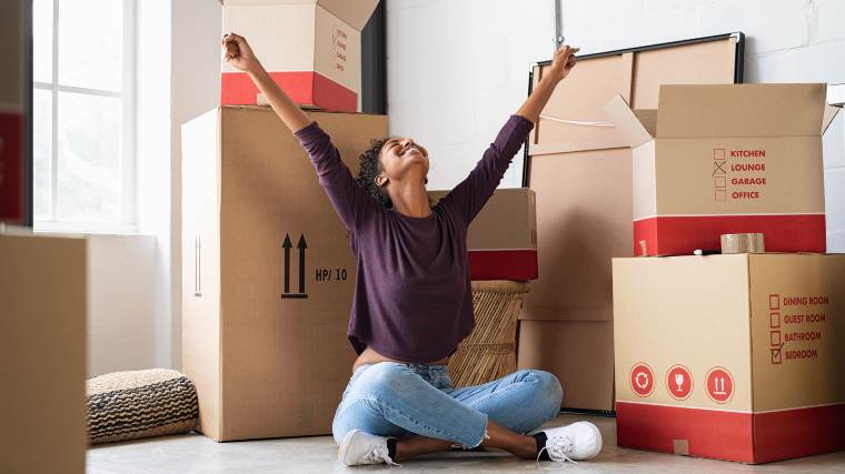 Woman with packing boxes in new home.