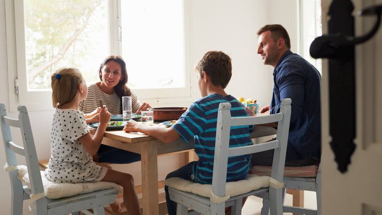 Family of four sitting together at the dinner table.