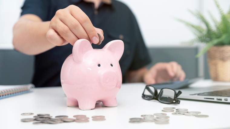 man with piggy bank and laptop