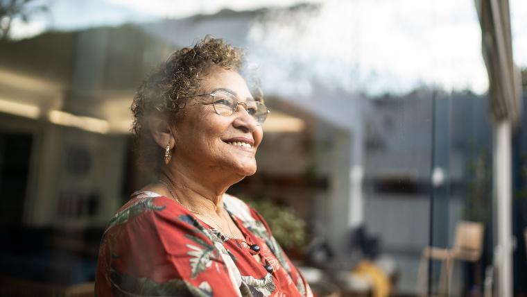 Happy woman looking out window.