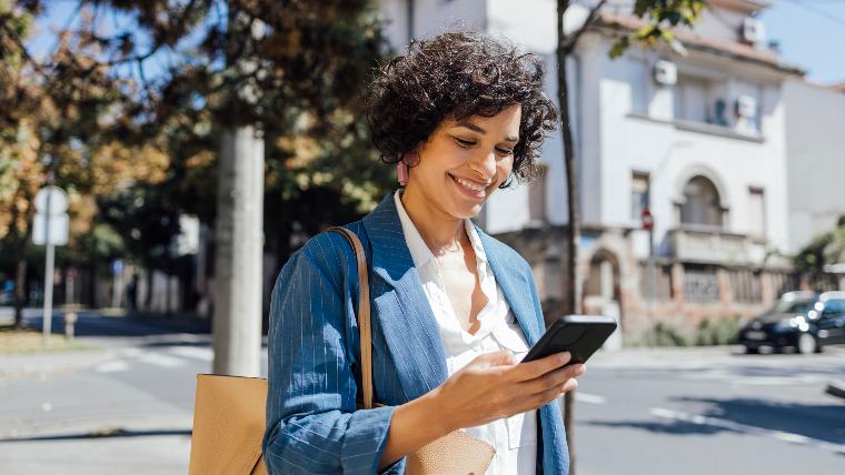 Woman looking pleased while using phone.