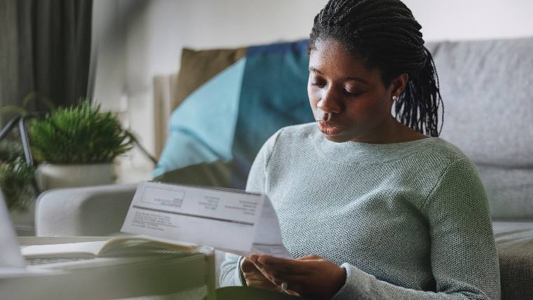 Woman reading her student loan bill.