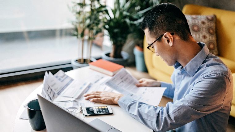 Man reviewing a stack of bills.