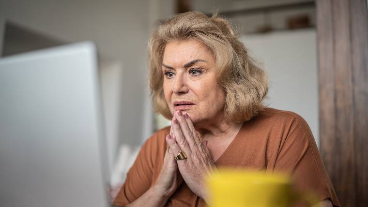 Concerned woman using laptop.