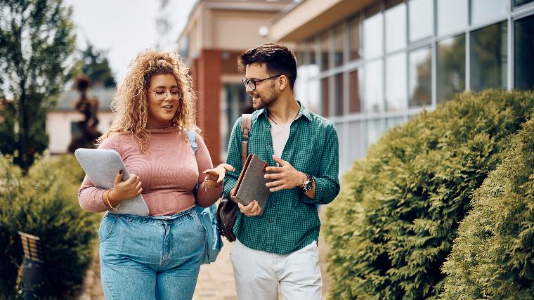 Two college students walking and talking.