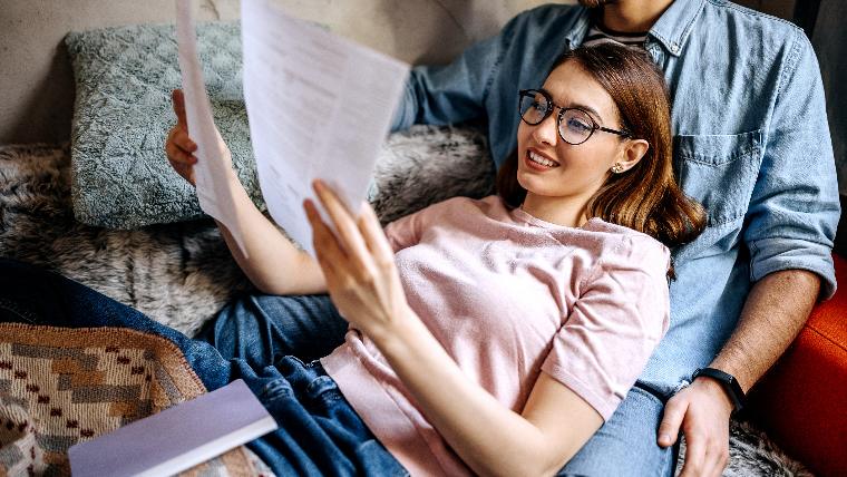 Young woman reviewing paperwork with her partner.