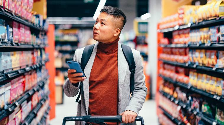 Man walking down aisle in store.