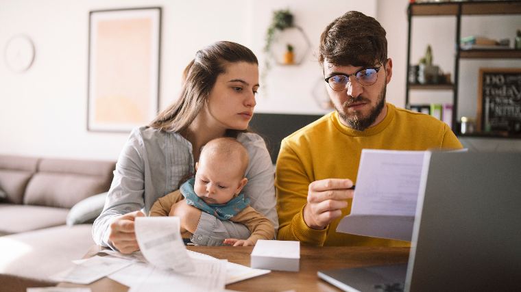 Couple with baby reading paperwork.