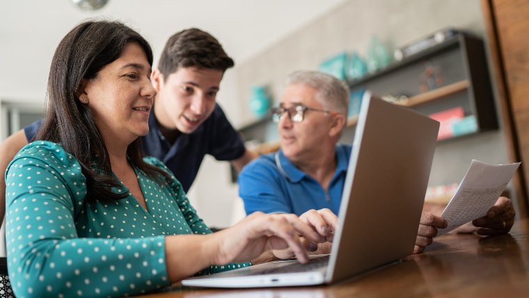 College aged son and parents looking at a laptop.