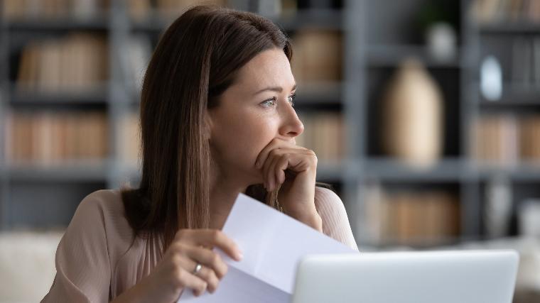 Distressed woman reading letter.