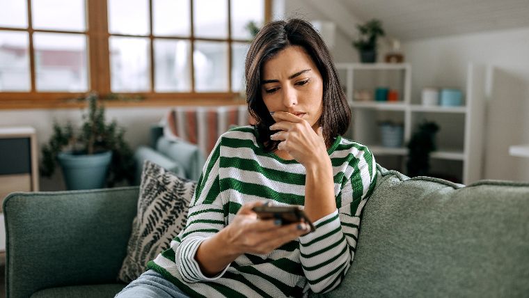 Woman reading bad news on her phone.