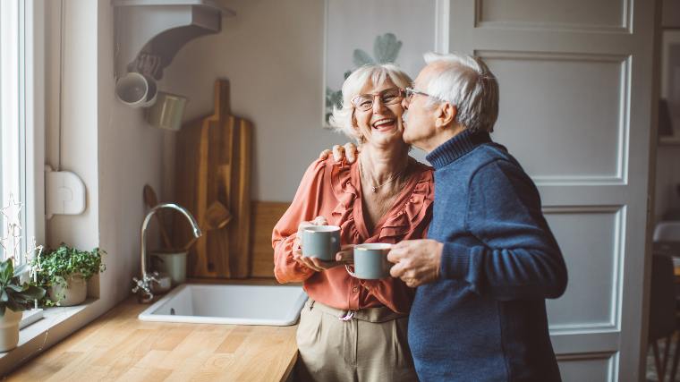 Senior couple together in kitchen.