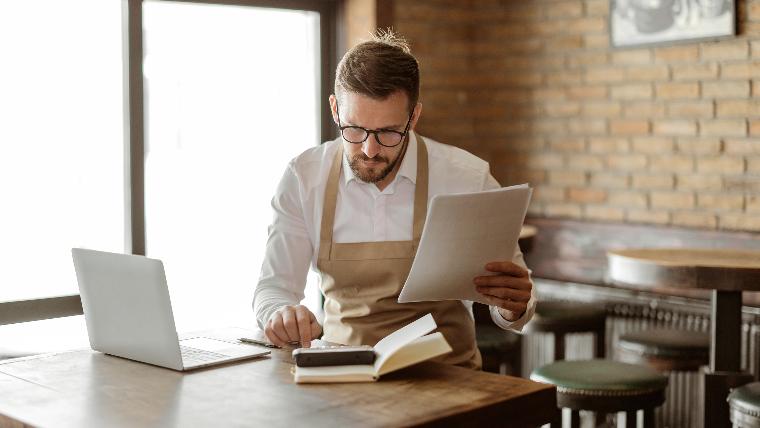 Man reviews his finances in a cafe.