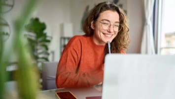 Happy young woman using a laptop.