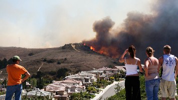 Onlookers watch wildfire in the distance.
