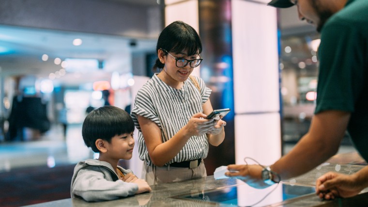 Young mother with son making payment at counter.