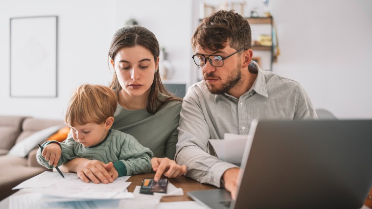 Young couple with child reviewing finances.