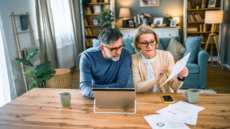 Mature couple reviewing financial documents together.