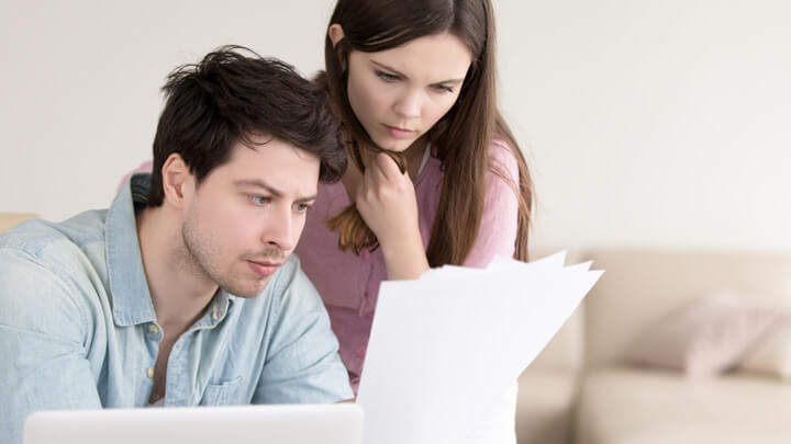 Young couple considering how to pay down their student loans