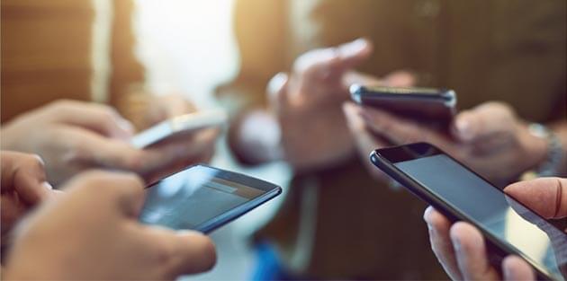 Four People Using Smart Phones