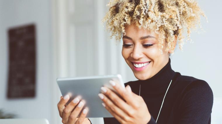 Young woman with tablet reviewing debt management plan savings.